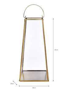 A large brass lantern. Delicate brass structure with glass sides. A moving handle to the top so it can be placed up or down. A flat base in brass to stand a pillar candle on. THe underneath has a black felt base so it can be stood on a table or on a fireplace hearth.