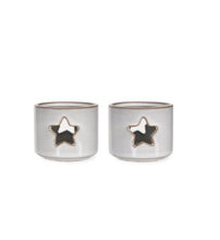 Load image into Gallery viewer, In a soft white ceramic glaze, this pair of tea light holders are small in size. Just the right size for that tea light. With a star cut out front and back they will glow when the candle is lit.
