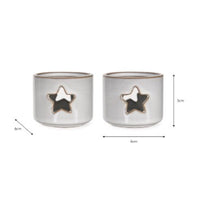 Load image into Gallery viewer, In a soft white ceramic glaze, this pair of tea light holders are small in size. Just the right size for that tea light. With a star cut out front and back they will glow when the candle is lit.