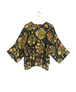 A bestselling kimono from One Hundred Stars in a print, with a black background, and an all over print. Loose 3/4 sleeves and an open front with a lightly embroidered lapel.