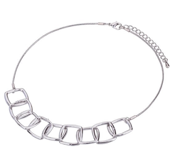 A silver necklace with square links to the front which interlock and give a 3D illusion when worn. With a clasp fastening and an extender chain to the back. 