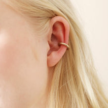 Load image into Gallery viewer, A matte gold hoop ear cuff, simply perfect for simply over your ear if you haven&#39;t got a helix piercing. In an organic textured finish. 