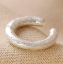 Load image into Gallery viewer, A matte silver organic finish to this ear cuff. A simple hoop style but a chunky look, simply slip it over your ear where a helix piercing would go. Sterling silver plated brass. 