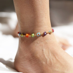 This beautiful ladies anklet features square millefiori beads in bright and bold colours with a mixture of ditsy floral designs, all separated by tiny round gold-plated beads. It has a lobster clasp to fasten and an extender chain that allows you to alter the size. 