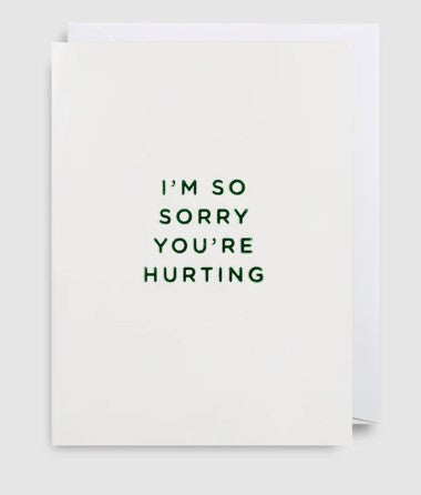 A very simple white card with the words Im so sorry youre hurting written on the front in green. Blank inside. 