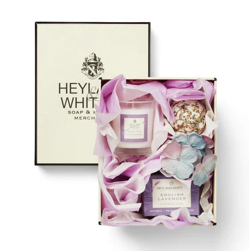 A Heyland & Whittle gift box containing a scented candle, soap and a bath melt, all nestled in purple tissue ready to gift. Lavender scented, perfect for relaxation and sleep. 