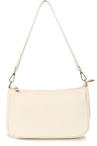 A classic leather baguette style handbag in cream. With gold hardware and a zip fastening to the top. Two detachable straps, one to be worn on the shoulder, and the longer length and adjustable strap to be worn long or across the body. Fabric lining with a zipped inner pocket and two inner pockets. 