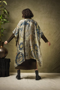 A lightweight, mid length kimono throwover in a design inspired by hand woven carpets, in soft beige/green with images in rust and navy