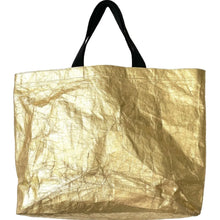 Load image into Gallery viewer, A giant gold sturdy shopper made from 100% recycled paper and woven fabric straps in black.