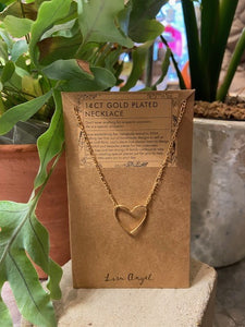 A 14ct gold plated brass necklace. The pendant to the front is shaped as the outline of a heart. It is attached either side to a figaro style chain. With a soft sheen. Lobster clasp and extender chain to the back. 