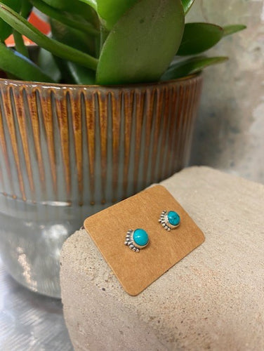 A turquoise stone encased and set in sterling silver 925. With a delicate filigree design to one edge of each earring. With a butterfly fastening to the back. 