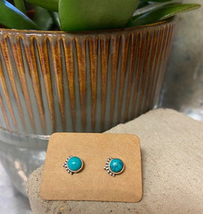 A turquoise stone encased and set in sterling silver 925. With a delicate filigree design to one edge of each earring. With a butterfly fastening to the back.