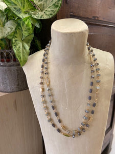 A short ladies necklace with beads in grey and gold in various shapes and shades. A double layered style fastened by a clasp at the back which is adjustable. 