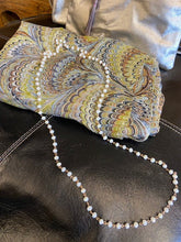 Load image into Gallery viewer, A long ladies necklace made from soft white iridescent beads attached to gold metal loops. Fastens with a clasp. Nickel free. 