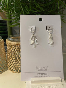 A simple silver hoop earring with strands of silver beads which hang from the base, with a mother of pearl charm to each, 