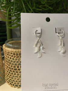 A simple silver hoop earring with strands of silver beads which hang from the base, with a mother of pearl charm to each,