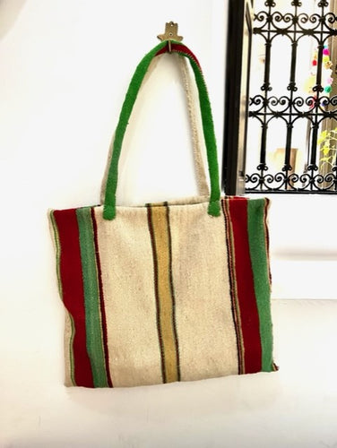 A truly unique tote bag. Handmade in Marrakech it features vertical stripes in neutral, red and yellow and green and a very subtle hint of brown. A large and spacious tote bag to wear over your shoulder. 