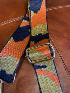 A detachable and adjustable bag strap. In navy, orange and gold glitter camouflage print. Woven and soft and comfortable to wear. With gold hardware and clips to simply attach to your bag.