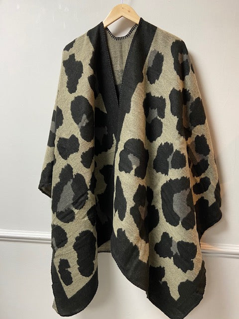 This ladies cape is supersoft and luxuriously warm to the touch. Like an oversized scarf, this cape simply drapes over your shoulders to keep you effortlessly warm and stylish. Wear like a cardigan or a coat over any outfit. In a black large oversized leopard print design, with black blanket stitching to all edges. One size. 