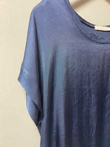 A silky fabric boxy style top. With short sleeves and a scoop neck, the fabric has a shimmer to it. With a double layer to the cuffs, neckline and hem, it is a luxe ladies top.