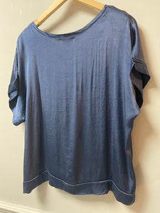 A silky fabric boxy style top. With short sleeves and a scoop neck, the fabric has a shimmer to it. With a double layer to the cuffs, neckline and hem, it is a luxe ladies top.