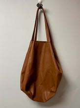 Load image into Gallery viewer, A beautiful tan leather handbag handmade in Marrakech. Morocco. It is a sizeable bag slouchy in nature. The inner leather ties can be secured to make the bag smaller, or keep them loose and the bag is large and spacious. With an inner zipped pocket and inner pockets.