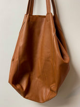 Load image into Gallery viewer, A beautiful tan leather handbag handmade in Marrakech. Morocco. It is a sizeable bag slouchy in nature. The inner leather ties can be secured to make the bag smaller, or keep them loose and the bag is large and spacious. With an inner zipped pocket and inner pockets.
