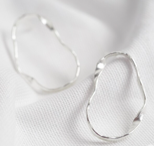 These sterling silver plated earrings are a unique twisted style. They are a wavy outline hoop style, fixed to posts at the top. 
